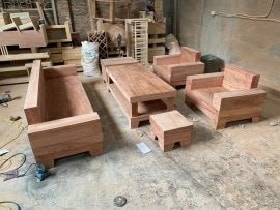 Bộ sofa gỗ hương đá nguyên khối, hàng dày dặn, kiểu dáng vuông vắn, không đục họa tiết mà để trơn toàn bộ bàn và ghế.